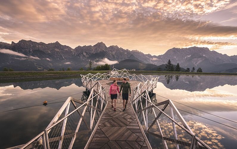 Maria Alm in summer, a couple walking on the Natrun lake bridge at sunset