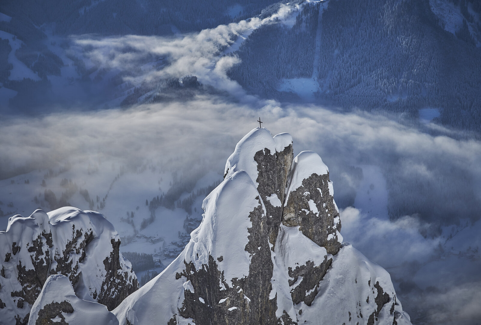 Saalbach in winter, snow-capped summit above the clouds